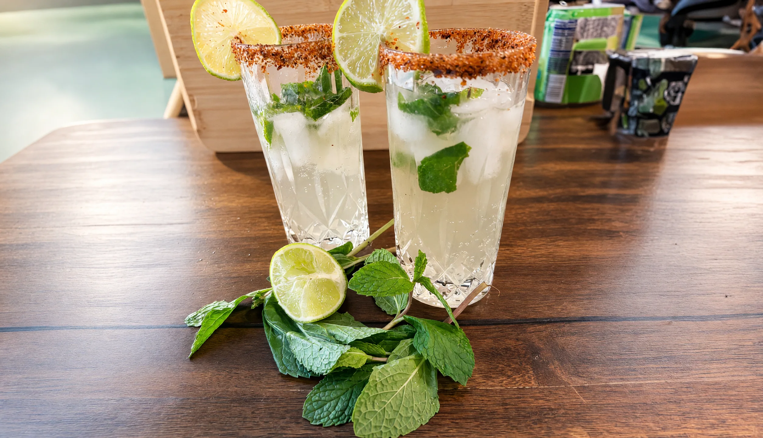 Two virgin mojitos with lime and mint on a wooden table