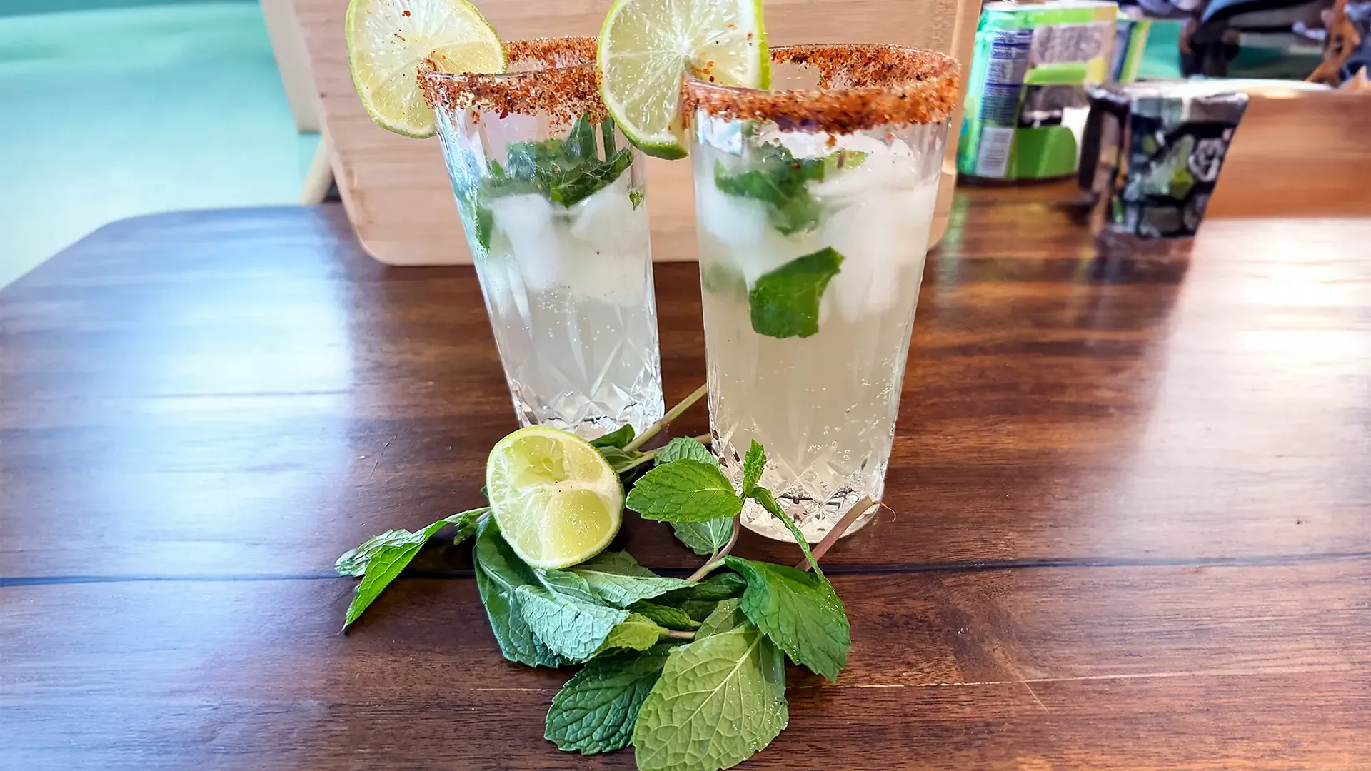 Two virgin mojitos with lime and mint on a wooden table