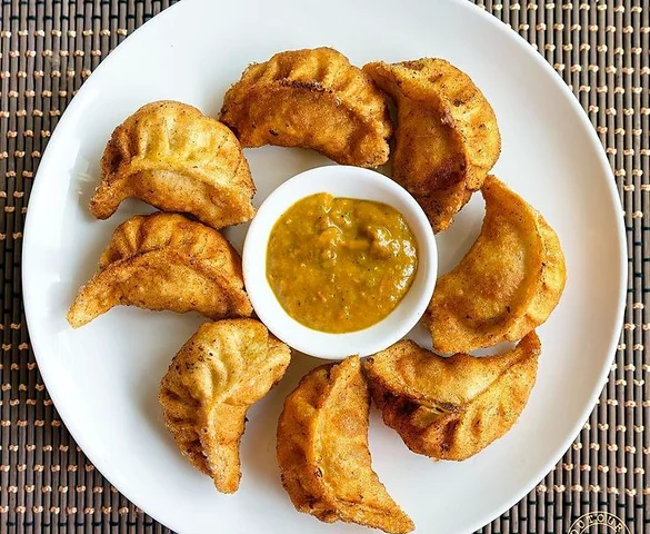 Fried Momo: pan-fried momos around a bowl of achar